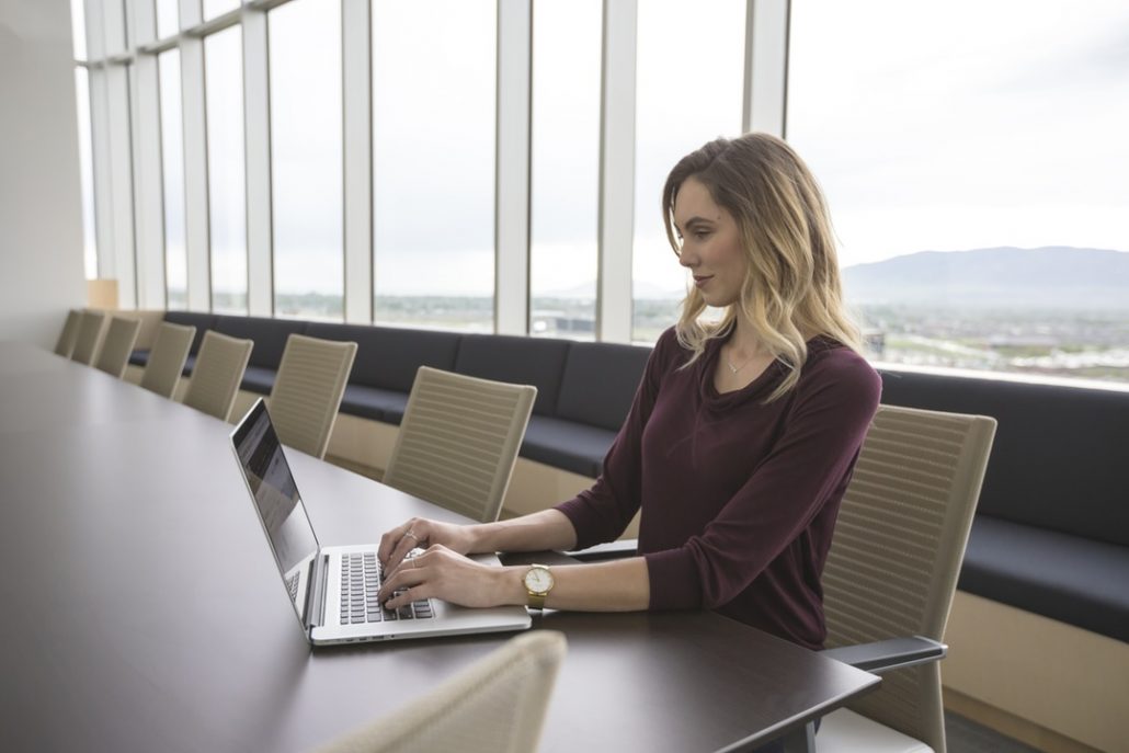 Female real estate agent working on a laptop in a business setting